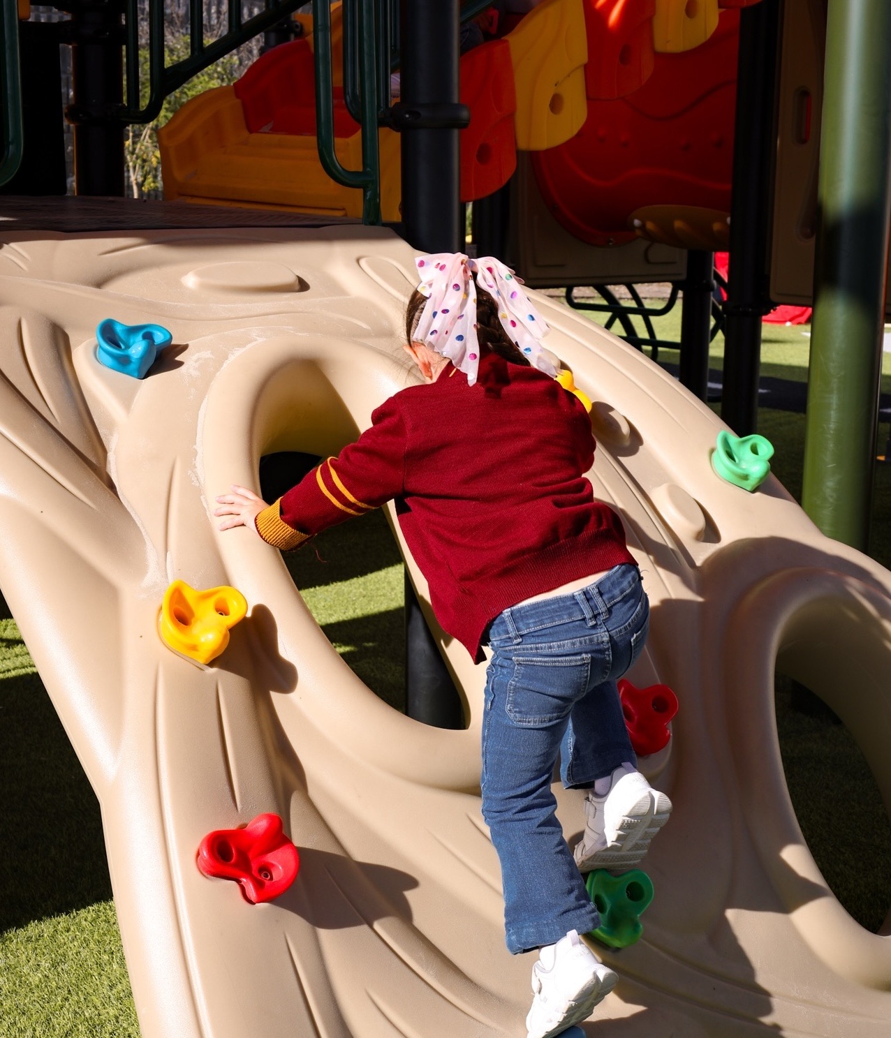 Child climbing on playground equipment at Newland Kinder