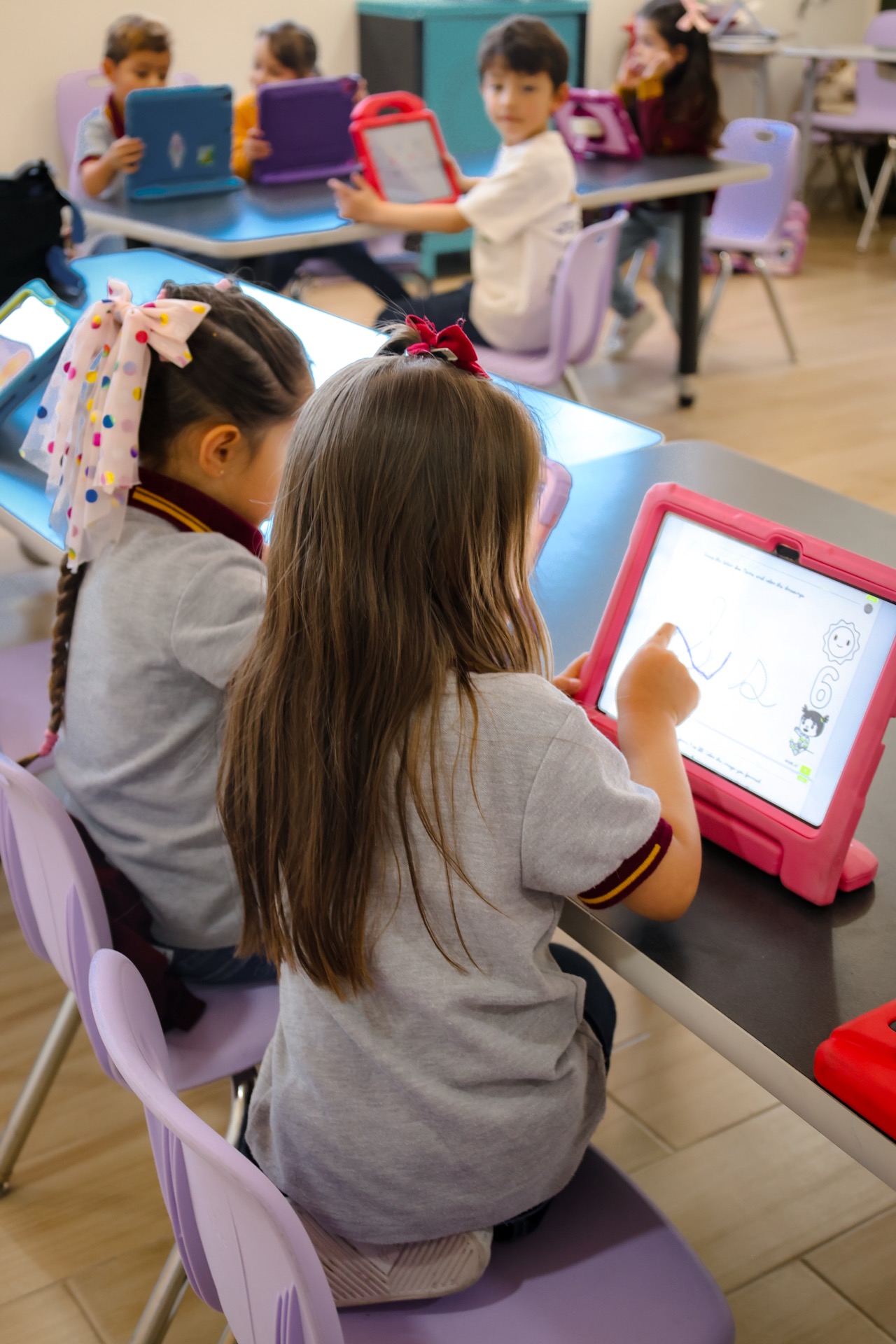 Kinder students using tablets for digital learning at Newland