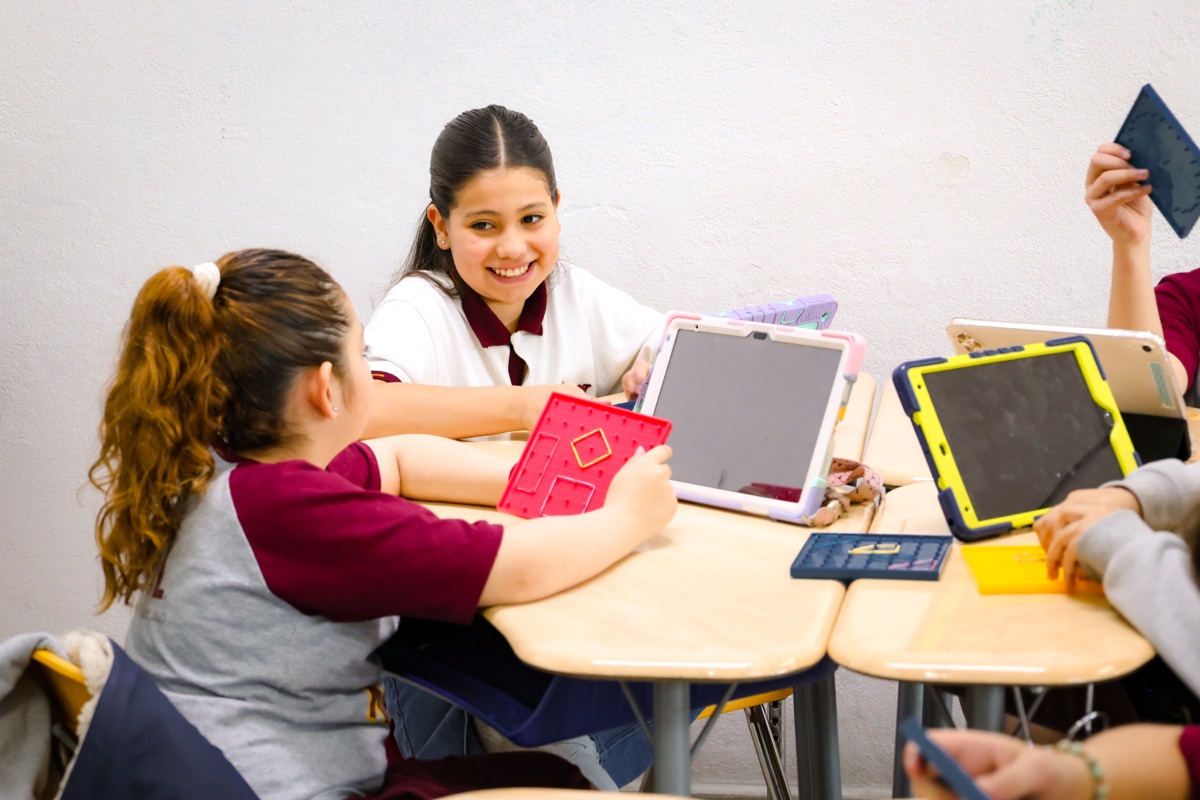 Newland Elementary students collaborating with tablets and Geoboard math app