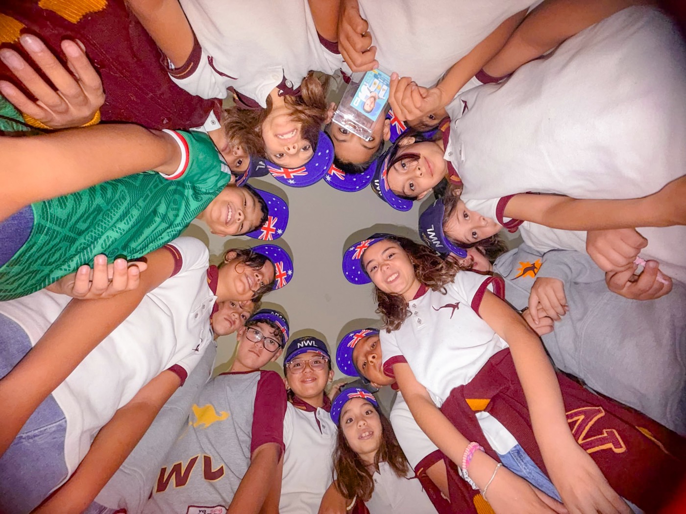 NWL students in Australian-flag hats gathered in a circle